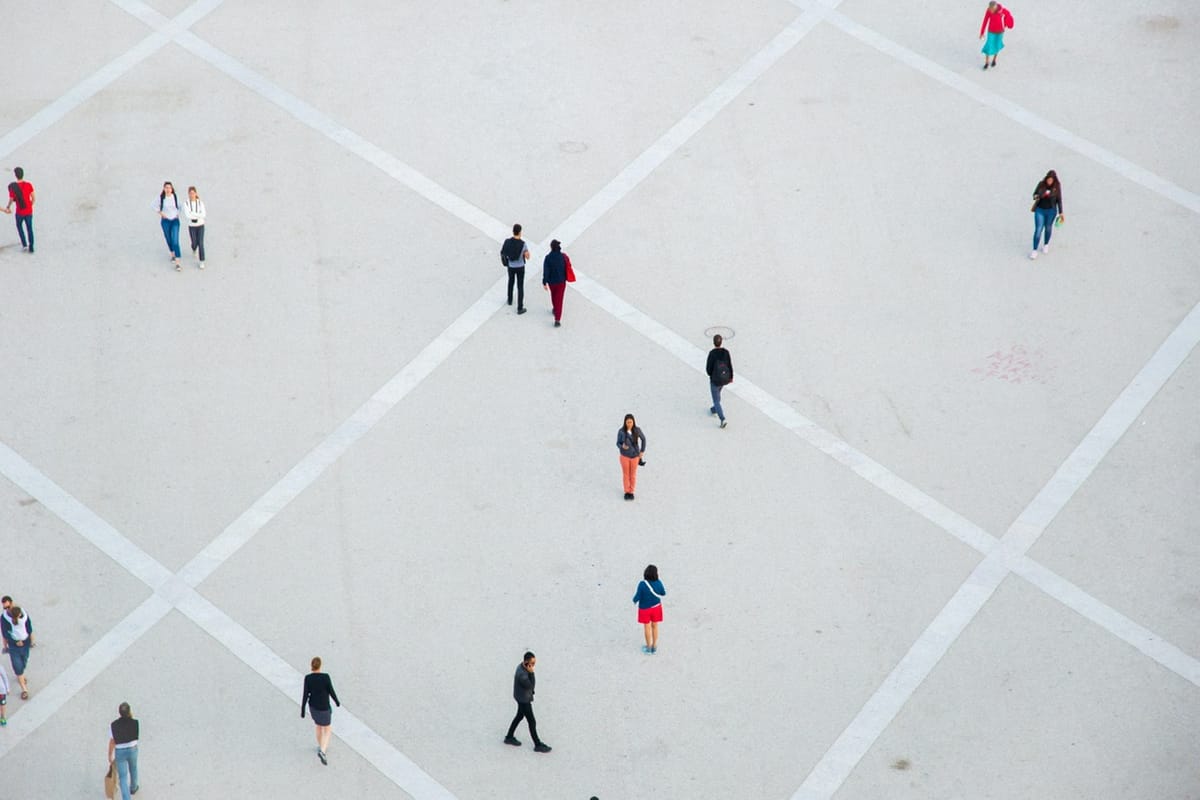 An aerial view of a space divided into squares with several people walking